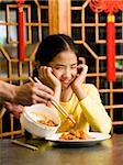 Fille assise à table, assiette de nourriture en regardant avec dégoût