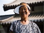 Woman with sun visor outdoors smiling