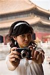 Teenager-Mädchen nehmen Foto im Freien mit Pagode im Hintergrund