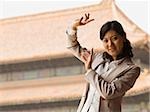 Businesswoman doing tai chi outdoors smiling