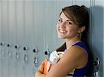 Cheerleader standing in front of lockers, smiling.