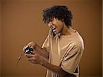 young man in a brown shirt playing a video game.