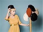 femme en costume des années 1960, essayer des chapeaux