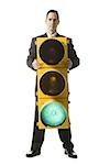 businessperson holding a traffic signal