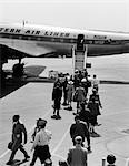 1950s 1960s AIRPLANE BOARDING PASSENGERS WALKING ACROSS TARMAC
