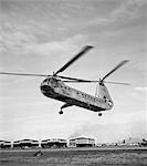 1950s AIR FORCE HELICOPTER TAKING OFF FROM BASE