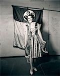 1910s 1920s YOUNG WOMAN COSTUME WITH SHAMROCKS ON HAT IRISH FLAG IN BACKGROUND