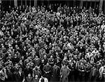 1940s CROWD OF MEN SEEN FROM ABOVE SINGING AT COLLEGE SPORTING EVENT