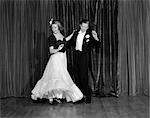 1940s COUPLE MAN AND WOMAN IN FORMAL WEAR BALLROOM DANCING ON STAGE