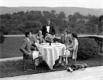 1920s 1930s COUNTRY CLUB SCENE WITH TWO COUPLES WITH GOLF CLUBS HAVING LUNCH OUTDOORS