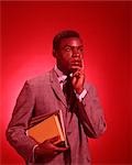 1960s AFRICAN AMERICAN MALE STUDENT CARRYING BOOKS