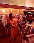 1960s WOMAN LOOKING AT SKIRT CLOTHING STORE