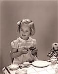 1930s 1940s LITTLE BLOND GIRL EATING JAM BREAD AT TEA PARTY WITH DOLL