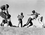 1940ER JAHRE-FOOTBALL-SPIELER, DIE BLOCKIERUNG VON CLEARING-PFAD FÜR SPIELER MIT BALL