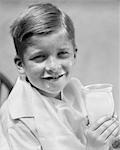 1930s FRECKLE FACED BOY SMILING AT CAMERA WITH A MILK MUSTACHE & DROP OF MILK ON HIS CHIN HOLDING A GLASS OF MILK WHOLESOME