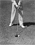 1930s 1940s MAN WAIST DOWN WITH GOLF CLUB ADDRESSING BALL