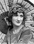 1920s PORTRAIT OF A WOMAN IN FRONT OF A JAPANESE PARASOL WEARING PEARLS AND A SILK PRINT HEADBAND