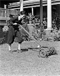 1930s 1940s BOY PUSHING LAWN MOWER WEAR KNICKERS CUTTING THE GRASS CHORE SUMMER JOB YARD WORK