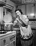 1950s HORRIFIED WOMAN HOUSEWIFE TAKING LID OFF COOKING POT BOILING OVER