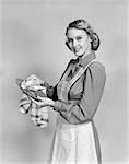 1940s SMILING WOMAN HOUSEWIFE WEARING KITCHEN APRON DRYING DISHES LOOKING AT CAMERA