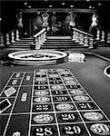 1960s CASINO VIEWED FROM END OF ROULETTE TABLE OPPOSITE OF WHEEL LOOKING TOWARD STATUES