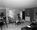 1950s LIVING ROOM INTERIOR WITH KIDNEY-SHAPED COFFEE TABLES FLOOR-LENGTH CURTAINS & VENETIAN BLINDS