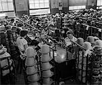 60ER JAHRE HUT-MAKING FACTORY MIT REIHEN VON FRAUEN AM LANGEN TISCH HAND-TRIMMING STETSON HÜTE