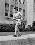 1940s SMILING TEEN GIRL ON ROLLER SKATES SKATING ON SIDEWALK