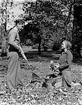 1930s 1940s YOUNG TEEN COUPLE BOY GIRL RAKING AUTUMN LEAVES