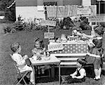 ANNÉES 1950 KIDS IN BACKYARD JOUANT MAGASIN AVEC SIGNES VENDANT DES SANDWICHS DE POMMES BANANES SUCETTES