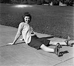 1940s LAUGHING YOUNG WOMAN TEEN GIRL SITTING ON SIDEWALK HAVING FALLEN DOWN ON ROLLER SKATES