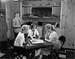 1950s GIRLS PLAYING SCRABBLE IN REC ROOM WITH BOY CHANGING RECORDS