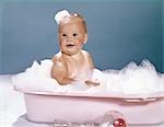 ANNÉES 1960 SOURIANT BÉBÉ EN BAIGNOIRE COUVERTE DE BULLES