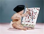 1960s BABY WEARING BLACK BERET SITTING IN FRONT OF EASEL PAINTING