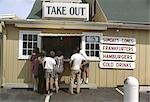 1970s GROUP OF PEOPLE AT TAKE OUT FAST FOOD COUNTER WINDOW SUNDAES CONES COLD DRINKS HAMBURGERS FRANKFURTERS OUTDOOR