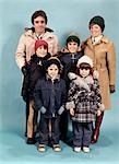 PORTRAIT DE FAMILLE DES ANNÉES 1970 PLEINE LONGUEUR PORTER HIVER MANTEAUX HOMME FEMME MÈRE PÈRE 4 ENFANTS GARÇONS FILLES