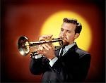 1960s MAN PLAYING TRUMPET RED YELLOW BACKGROUND