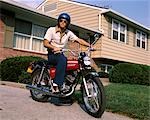 ANNÉES 1970 YOUNG MAN CASQUE BLEU ASSIS SUR MOTO IN PASTURE BANLIEUE MAISON MOTO MOTOS HOMMES