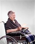 1960s SMILING SENIOR WOMAN SITTING IN WHEELCHAIR READING LETTER