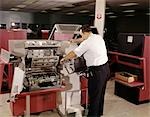 1970s MAN COMPUTER TECHNICIAN WORKING WITH COMPUTER PRINTER