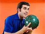 1960s CLOSE-UP OF YOUNG MAN HOLDING BOWLING BALL READY TO BOWL