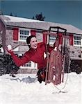 ANNÉES 1950 FEMME SE CACHANT DERRIÈRE LE TRAÎNEAU LEVER FAIRE BOULE DE NEIGE AVANT STONE HOUSE