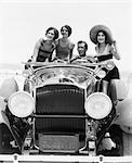 1920s 1930s MAN DRIVING CONVERTIBLE TOURING CAR WITH THREE WOMEN IN BATHING SUITS AS PASSENGERS