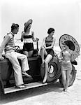 1920s 1930s MAN AND THREE WOMEN IN BEACH CLOTHES OR BATHING SUITS POSING WITH CAR ON RUNNING BOARD