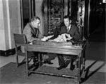 1930s TWO MEN SEATED AT TABLE BEFORE BANK VAULT SAFE DEPOSIT BOX CLIPPING COUPONS FINANCE SECURITY