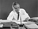 1950s MAN BUSINESS PAPERWORK TIRED OVERWORKED