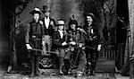 1890s TURN OF THE CENTURY PORTRAIT GROUP OF FIVE MEN ACTORS IN VARIOUS COSTUMES AGAINST PAINTED STUDIO BACKDROP