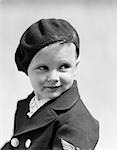 1930s STUDIO PORTRAIT OF YOUNG BOY LOOK TO THE SIDE WEARING A BERET AND A DOUBLE BREASTED JACKET