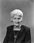 1950s PORTRAIT OF ELDERLY WHITE HAIRED WOMAN WITH SQUARE NECKED BLACK DRESS AND ANTIQUE JEWELRY