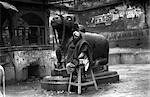1920s 1930s BENARES INDIA MAN IN TURBAN SEATED BY STATUE OF NANDI SCARED HINDU GOD BULL RELIGION HINDUISM